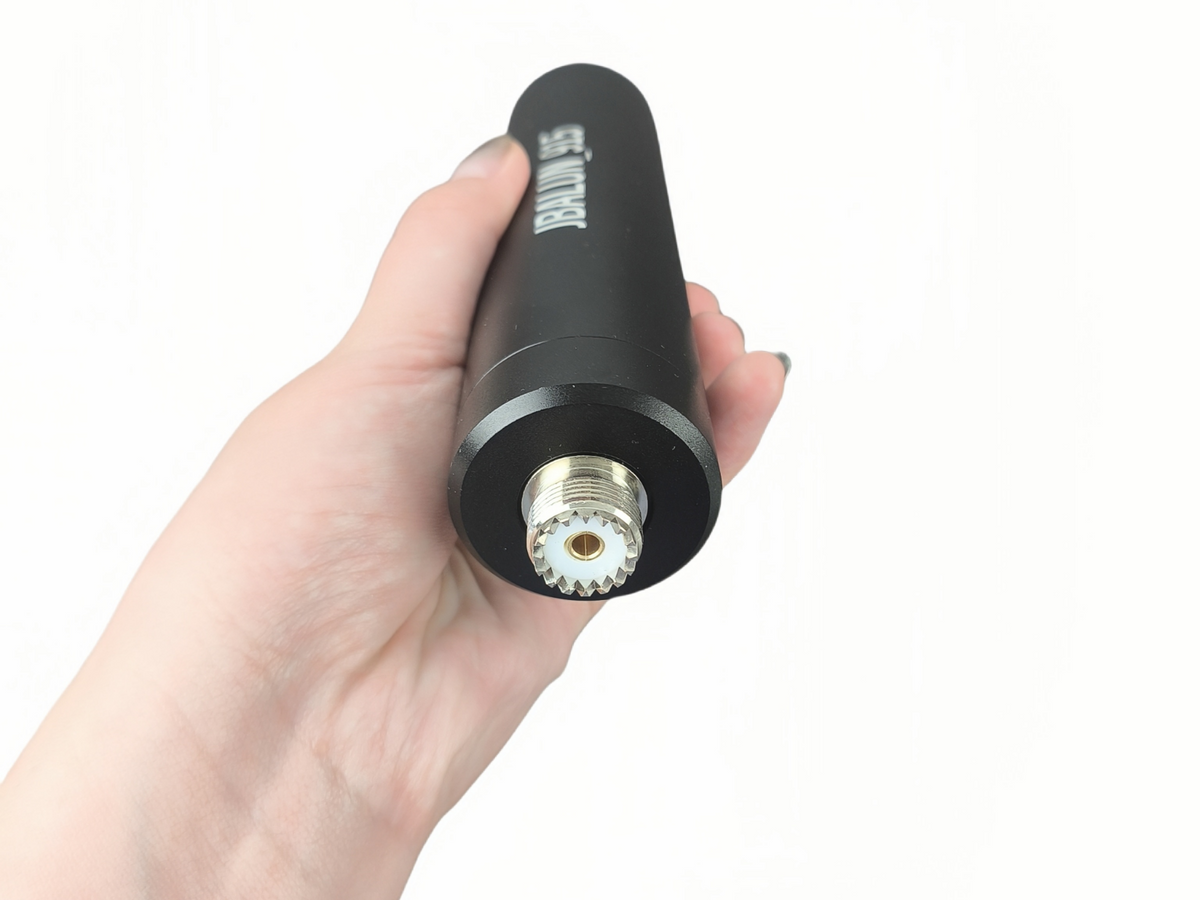 JBALUN-915 RF isolator held in a hand with the UHF female connector visible